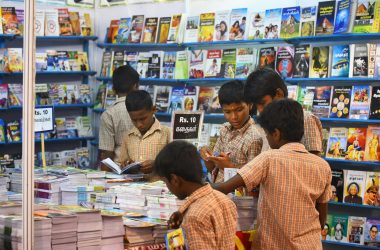 Children engaged in browsing books at a stall in Madurai, highlighting interest in reading and education.